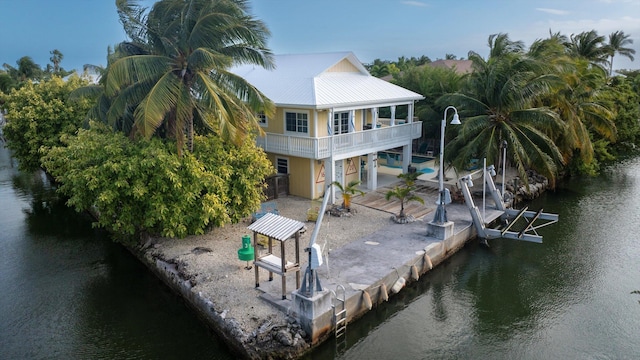 rear view of property with a water view and a patio