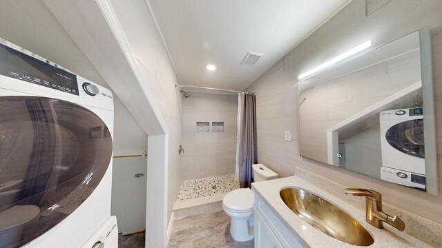 bathroom featuring vanity, washer / dryer, curtained shower, and toilet