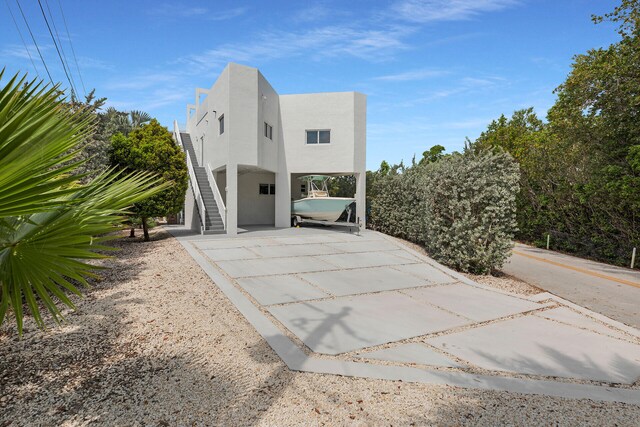 21 Lakeview Dr, Key Largo, FL 33037 - view of front of house featuring stairway, a carport, and stucco siding