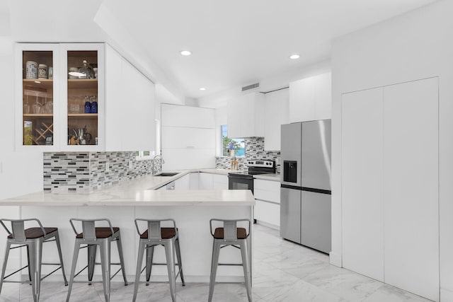 21 Lakeview Dr, Key Largo, FL 33037 - kitchen with stainless steel fridge, range with electric stovetop, a peninsula, a sink, and light marble finish flooring