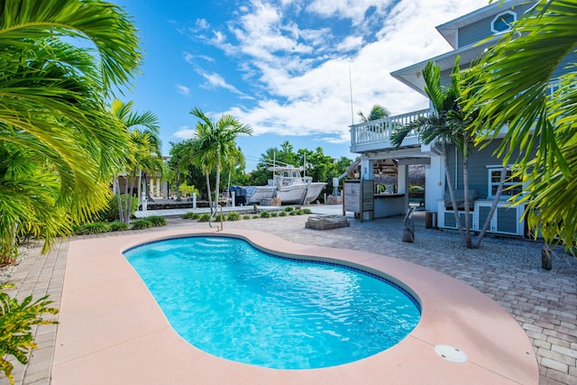 view of swimming pool with a fire pit, a patio area, and exterior kitchen