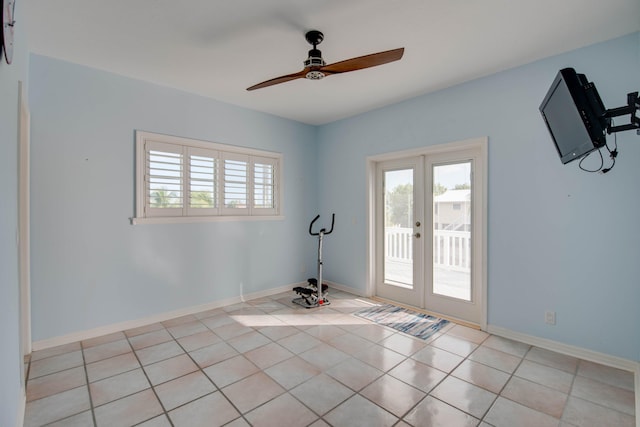 empty room with french doors, ceiling fan, and light tile patterned floors