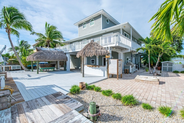 back of property featuring a wooden deck, a gazebo, a patio area, and a balcony