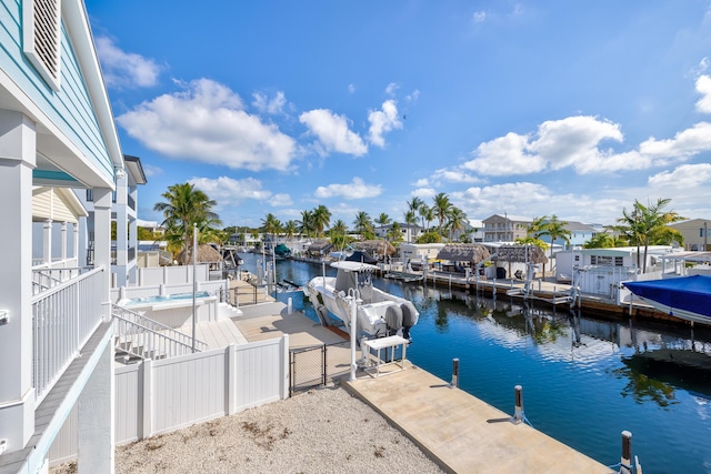 dock area with a residential view, a water view, boat lift, and fence private yard