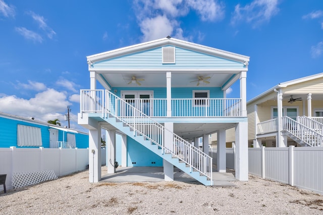 back of house with ceiling fan, fence, stairway, a porch, and a carport