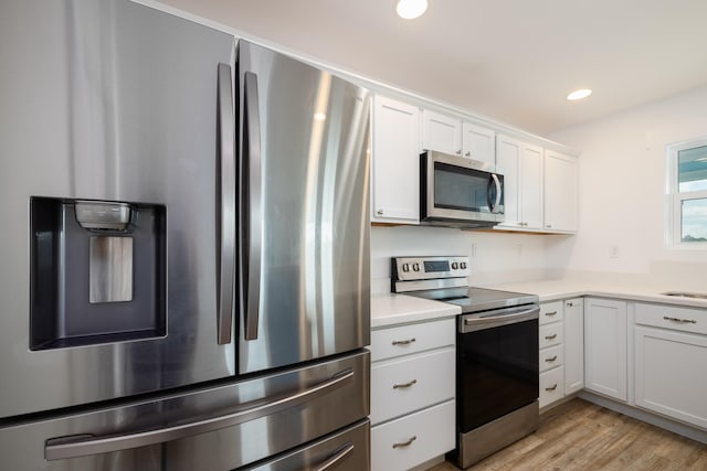 kitchen featuring white cabinetry, light hardwood / wood-style floors, and appliances with stainless steel finishes