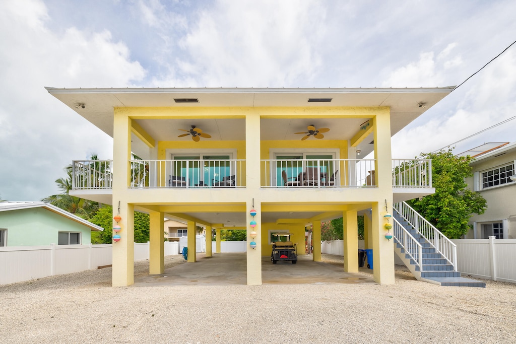 view of front of property featuring a carport, ceiling fan, and a porch