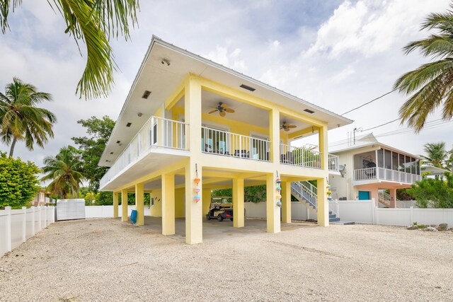 back of property with a carport and ceiling fan