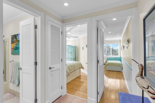 hallway with crown molding and light hardwood / wood-style floors