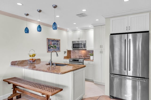 kitchen featuring decorative light fixtures, white cabinetry, sink, stainless steel appliances, and light stone countertops