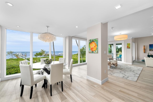 108 N Bounty Ln, Key Largo, FL 33037 - dining area with a water view, baseboards, light wood finished floors, and a wealth of natural light