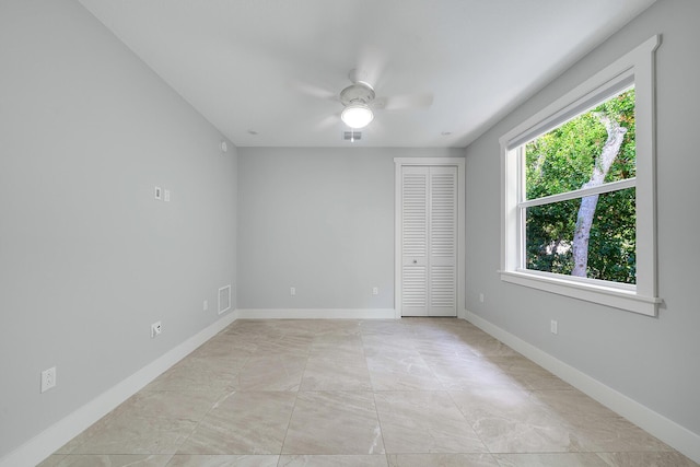 unfurnished bedroom featuring ceiling fan and a closet