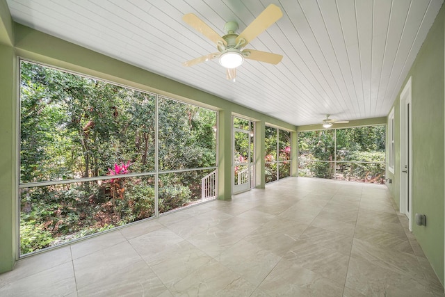 unfurnished sunroom featuring ceiling fan and wooden ceiling