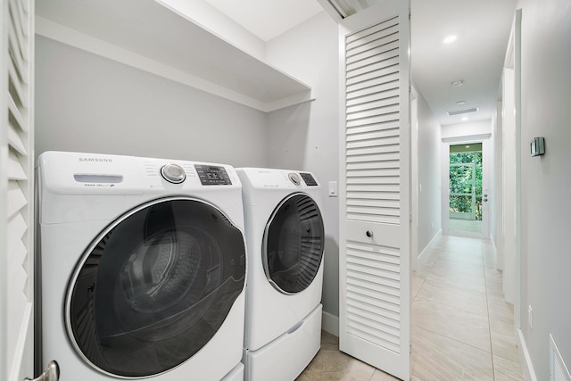 clothes washing area with light tile patterned flooring and washing machine and clothes dryer