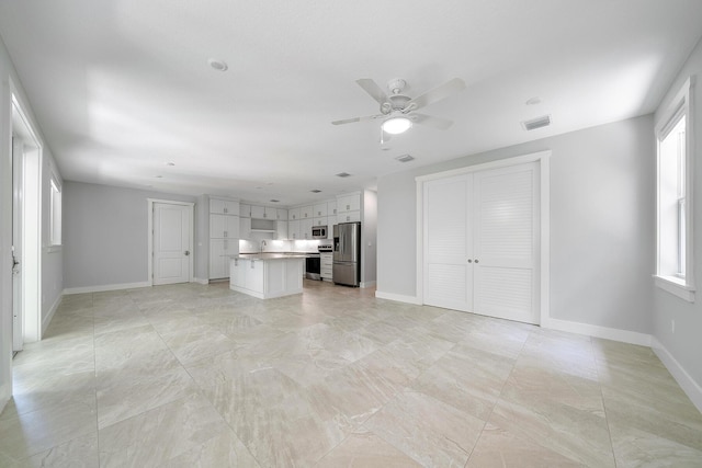 unfurnished living room with ceiling fan