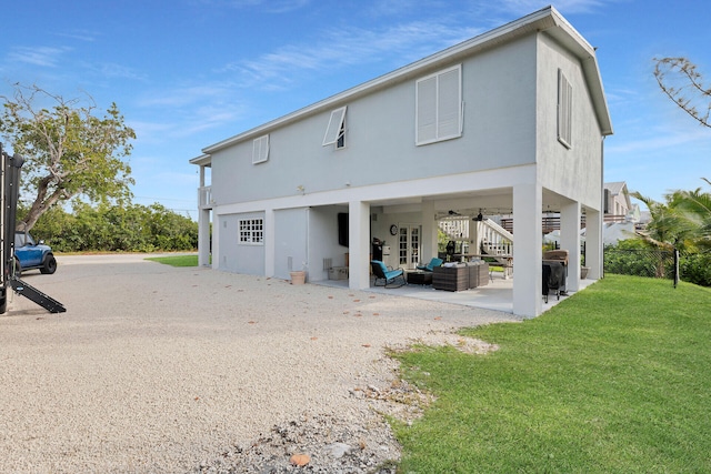 rear view of property with an outdoor hangout area, a patio, and a lawn