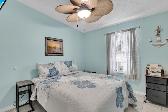 tiled bedroom with ceiling fan and a textured ceiling