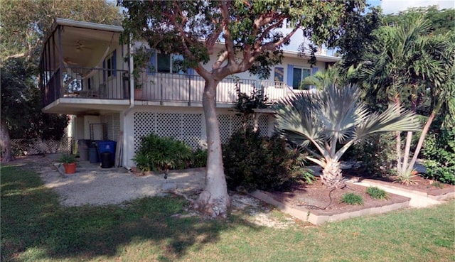 rear view of property featuring stairway and a lawn