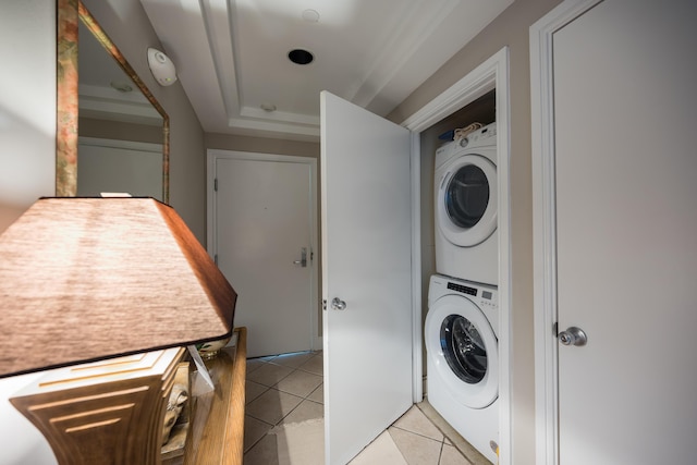 clothes washing area featuring stacked washer and dryer and light tile patterned floors