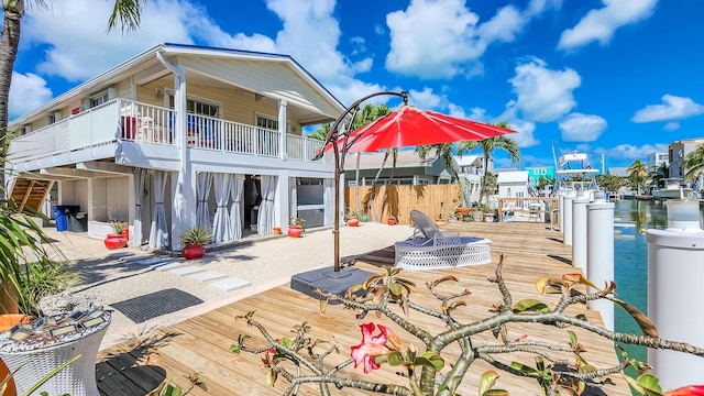 rear view of house featuring a balcony and a water view