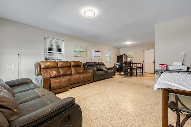 living area featuring light speckled floor and a wall mounted AC