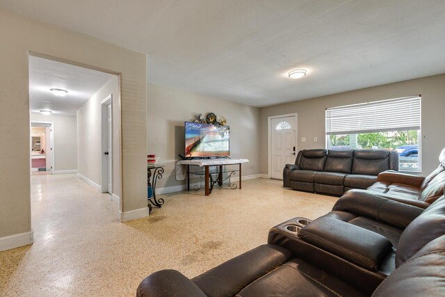 living room featuring baseboards and speckled floor