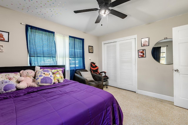 bedroom with ceiling fan, baseboards, a closet, and speckled floor