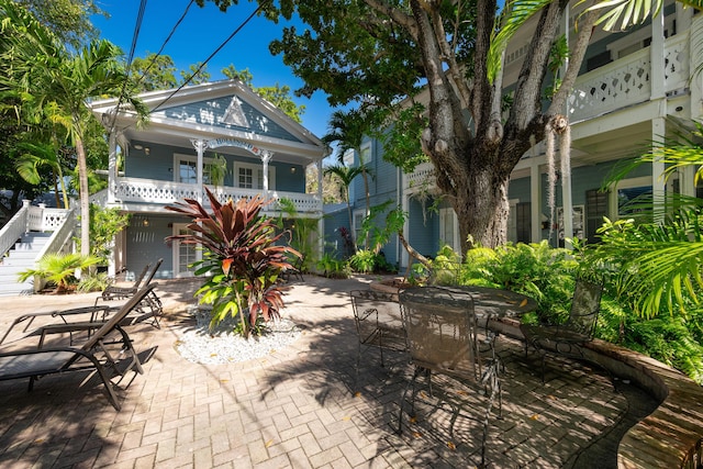 view of patio featuring outdoor dining area and stairway