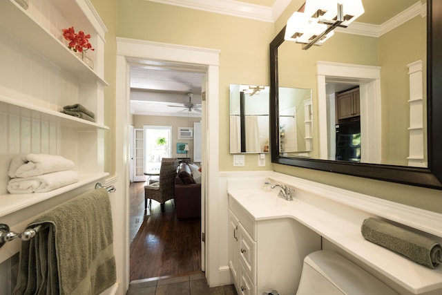 bathroom featuring a ceiling fan, toilet, ornamental molding, wood finished floors, and vanity