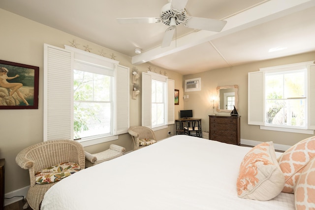 bedroom featuring a ceiling fan, baseboards, beamed ceiling, and a wall mounted AC