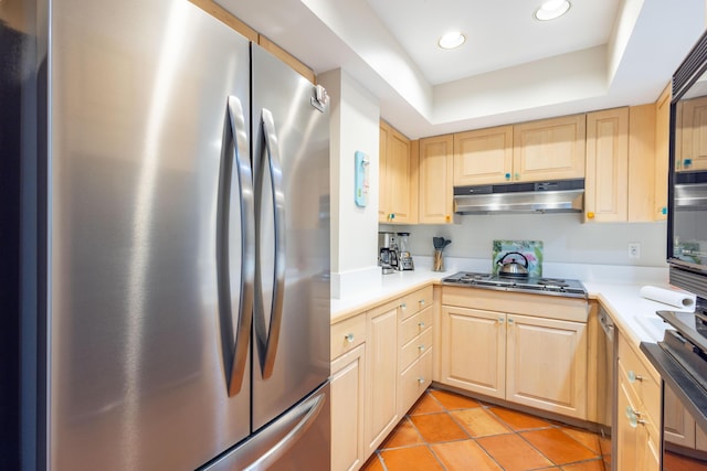 115 Front St Unit 102, Key West, FL 33040 - kitchen featuring freestanding refrigerator, stovetop, under cabinet range hood, light brown cabinetry, and light tile patterned flooring
