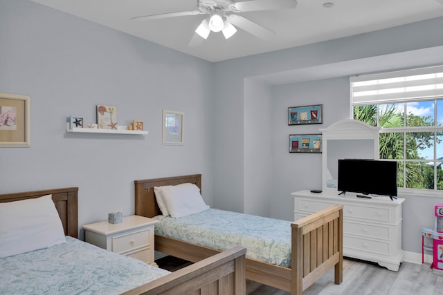 bedroom featuring ceiling fan, multiple windows, and light wood-type flooring