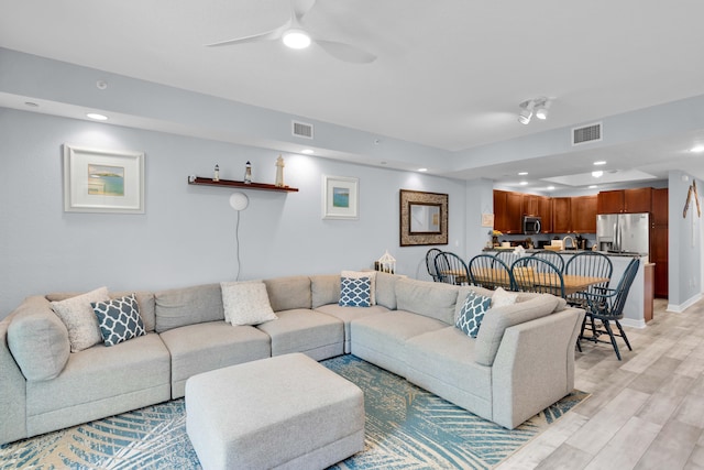 living room with ceiling fan and light wood-type flooring