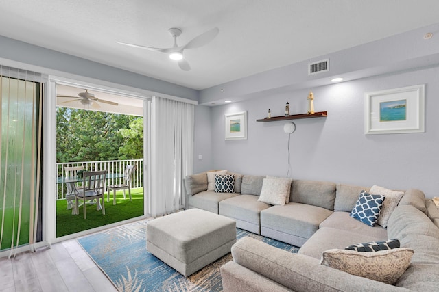 living room featuring wood-type flooring and ceiling fan