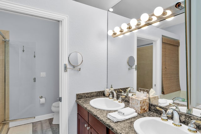 bathroom featuring a shower with door, wood-type flooring, vanity, and toilet