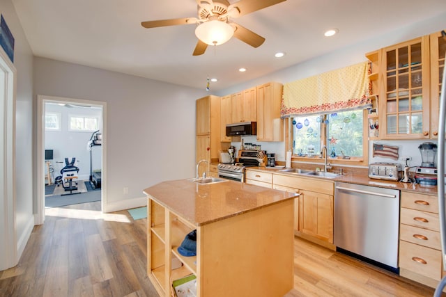 kitchen with a kitchen island with sink, sink, stainless steel appliances, and light brown cabinets