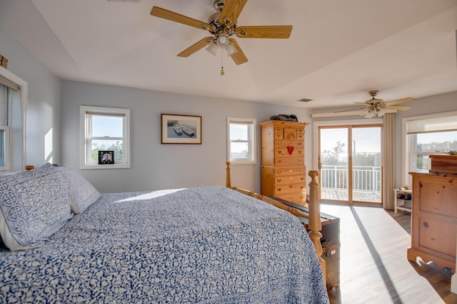 bedroom featuring ceiling fan, light hardwood / wood-style flooring, multiple windows, and access to outside