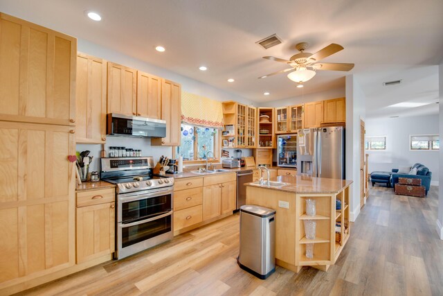 kitchen with a kitchen island with sink, light brown cabinetry, and appliances with stainless steel finishes