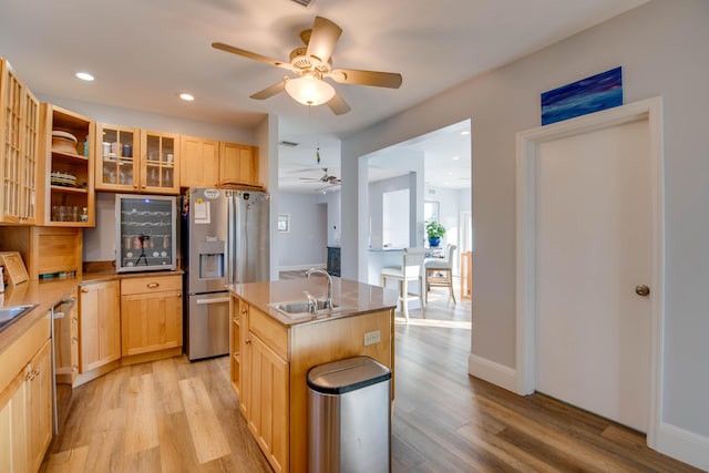 kitchen featuring sink, light hardwood / wood-style flooring, stainless steel appliances, a center island with sink, and light brown cabinets