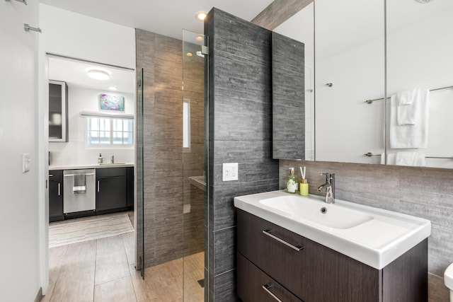 bathroom featuring a shower stall, backsplash, vanity, and tile walls