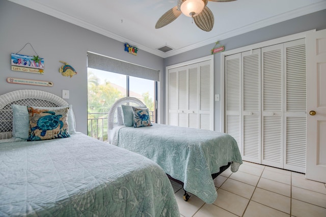 tiled bedroom featuring ceiling fan, crown molding, and multiple closets