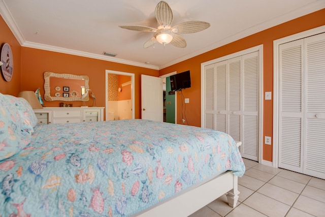 tiled bedroom with multiple closets, ornamental molding, and ceiling fan