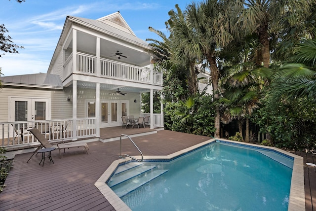 view of swimming pool with a wooden deck, french doors, and ceiling fan