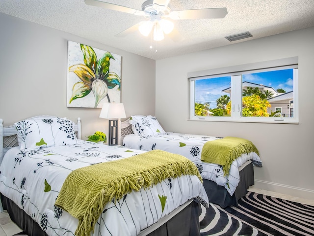 bedroom featuring ceiling fan and a textured ceiling