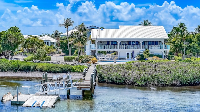 view of dock with a swimming pool, a patio, and a water view