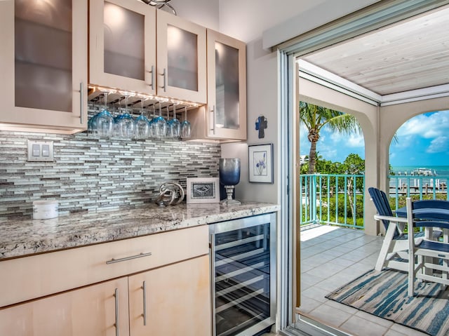 bar featuring tasteful backsplash, light tile patterned floors, wine cooler, and light stone counters