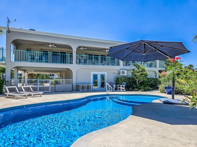 view of swimming pool featuring a patio area, ceiling fan, and french doors