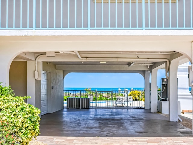 view of gate featuring a water view and a patio area