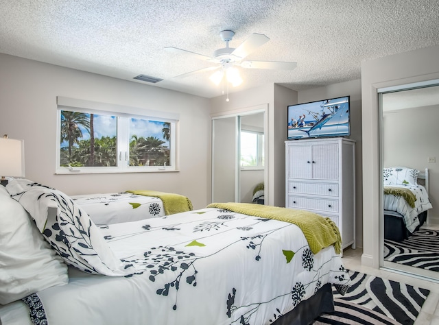 bedroom with ceiling fan and a textured ceiling