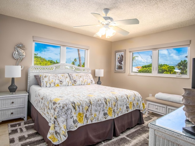 bedroom with ceiling fan and a textured ceiling